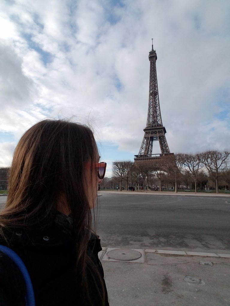 Woman wearing sunglasses looking at the Eiffel Tower in Paris