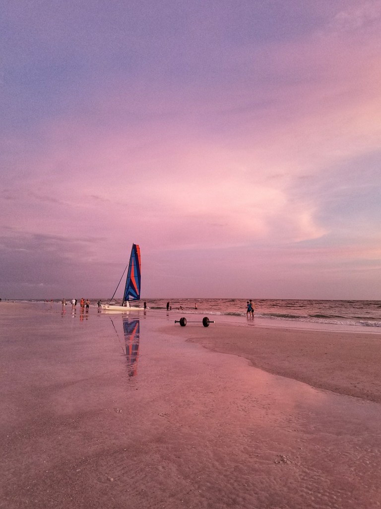 Siesta Key Beach sailboat with pink sky sunset in Sarasota, FL