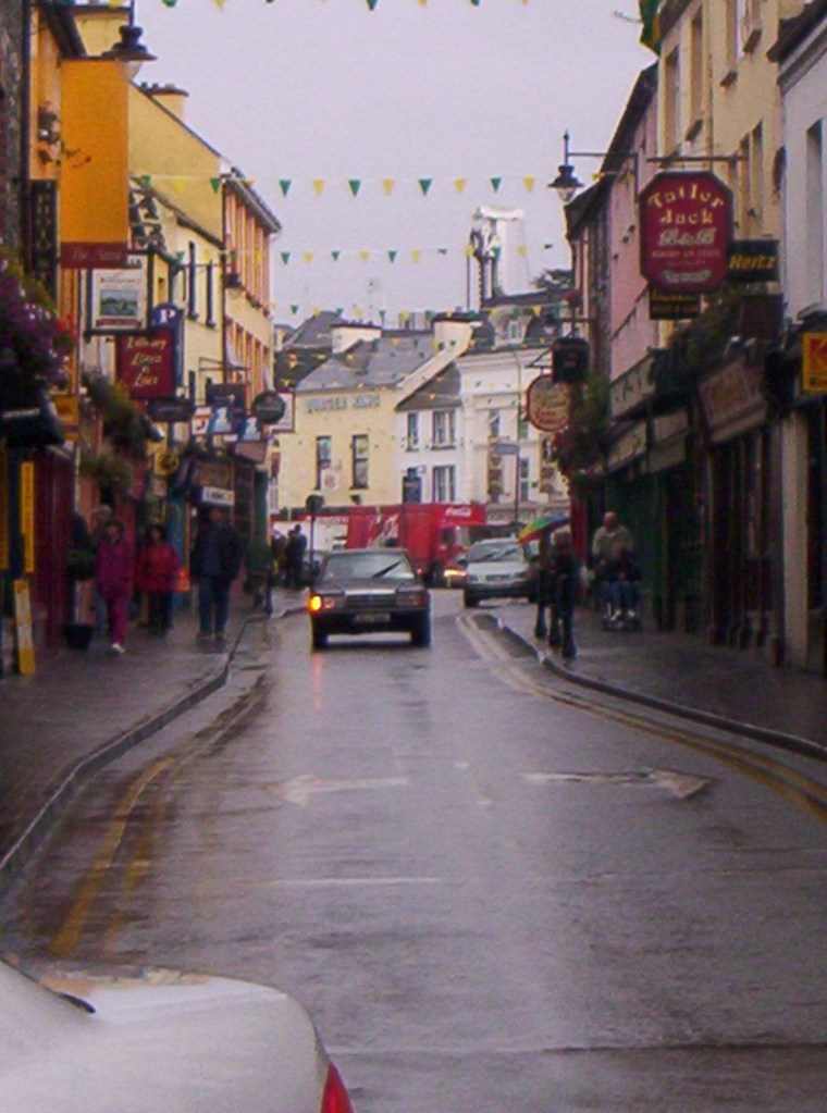 People and cars on a street in Killarney, Ireland