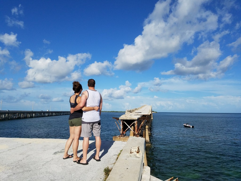 Man and woman looking at ruins of a bridge in the Florida Keys