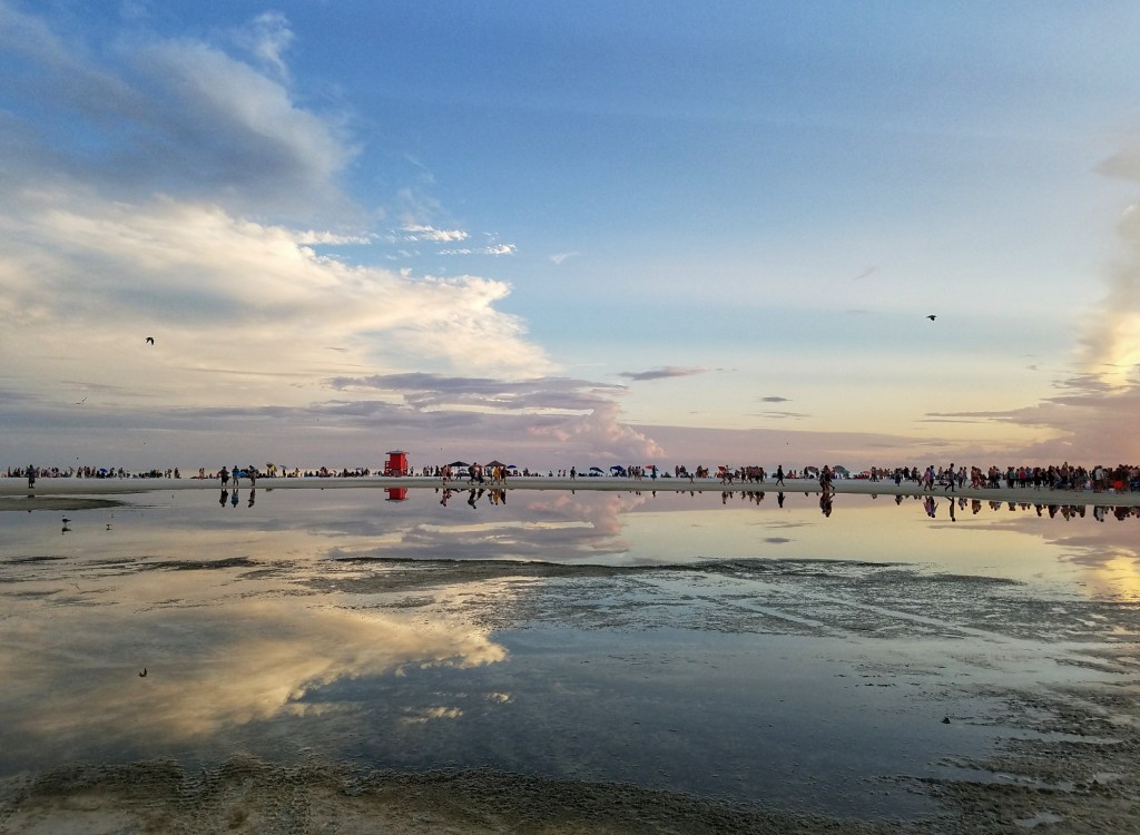 Tide pool reflections of people at the beach on Siesta Key in Sarasota Florida