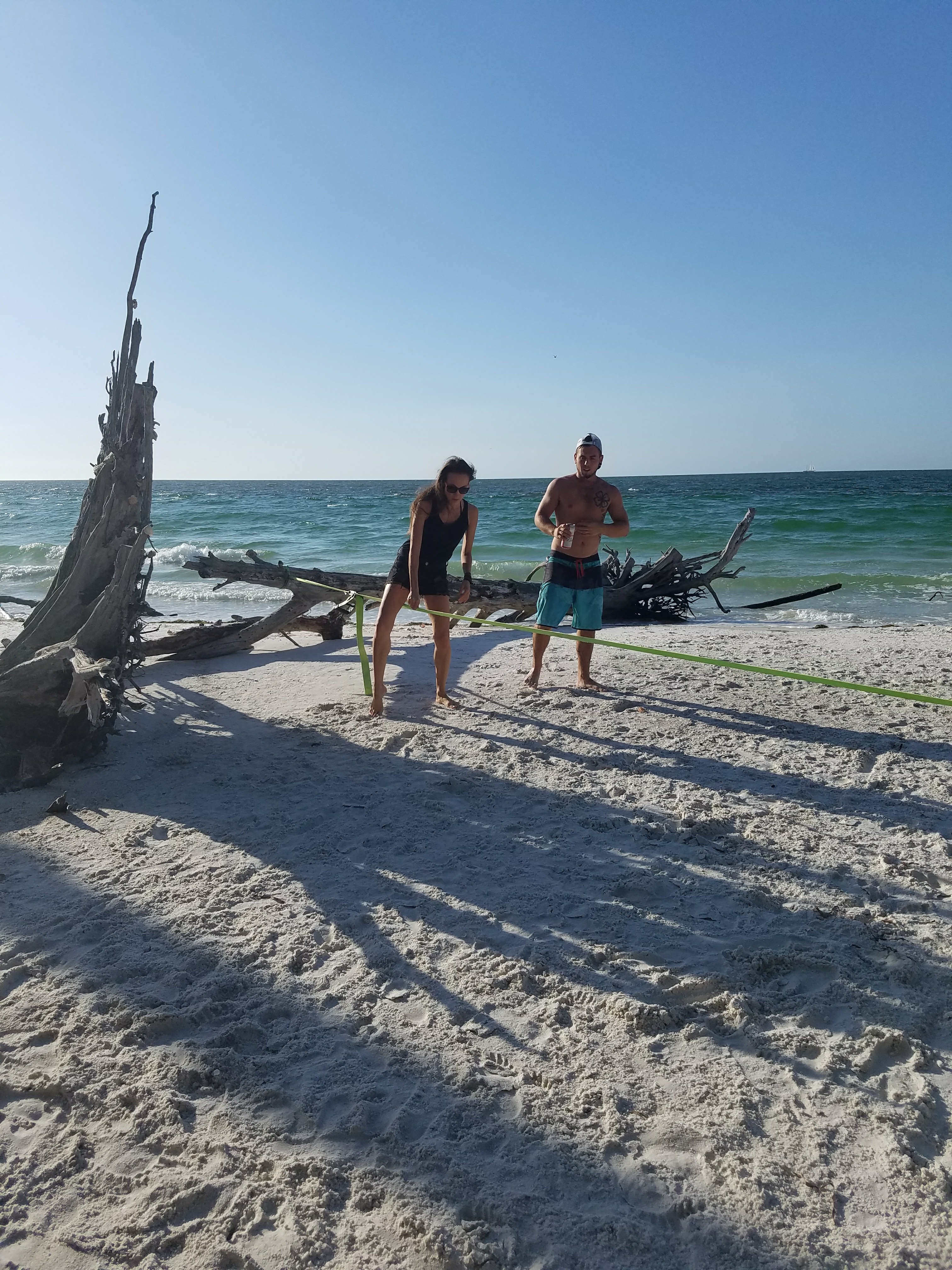 Woman attempting to walk a tightrope on the beach