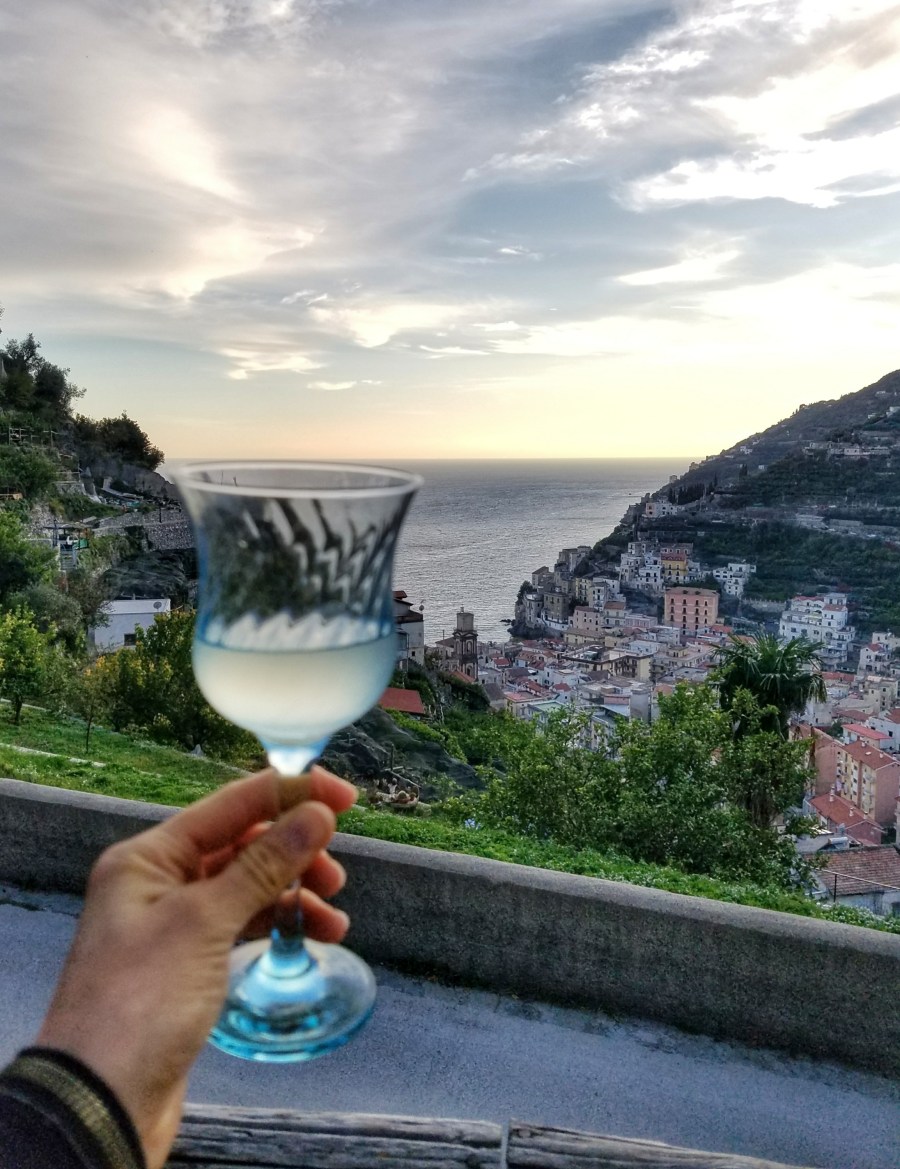 Hand holding a glass if limoncello on the Amalfi Coast, Italy