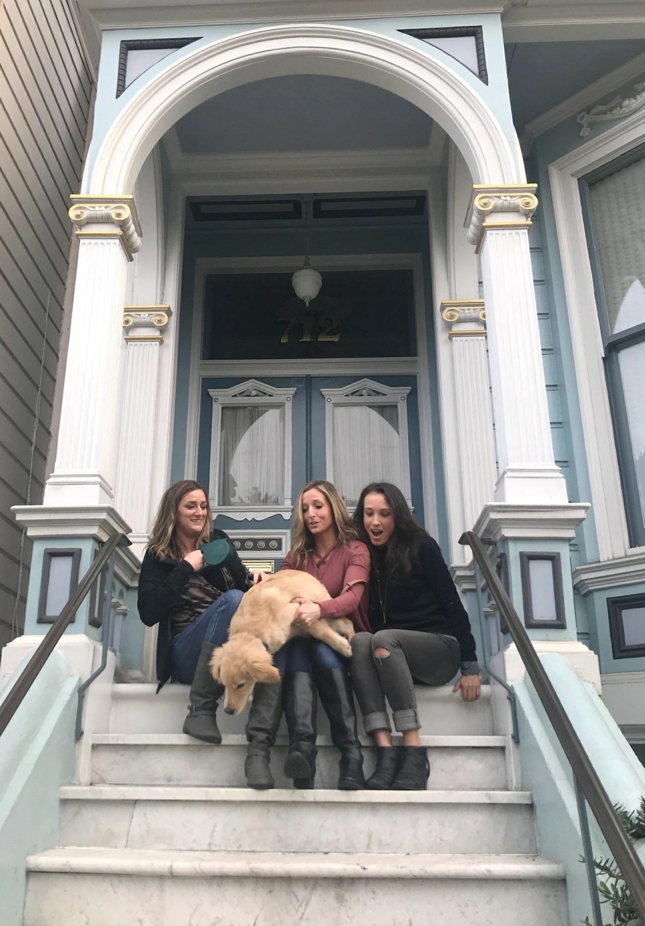 Three women holding a Golden Retriever
