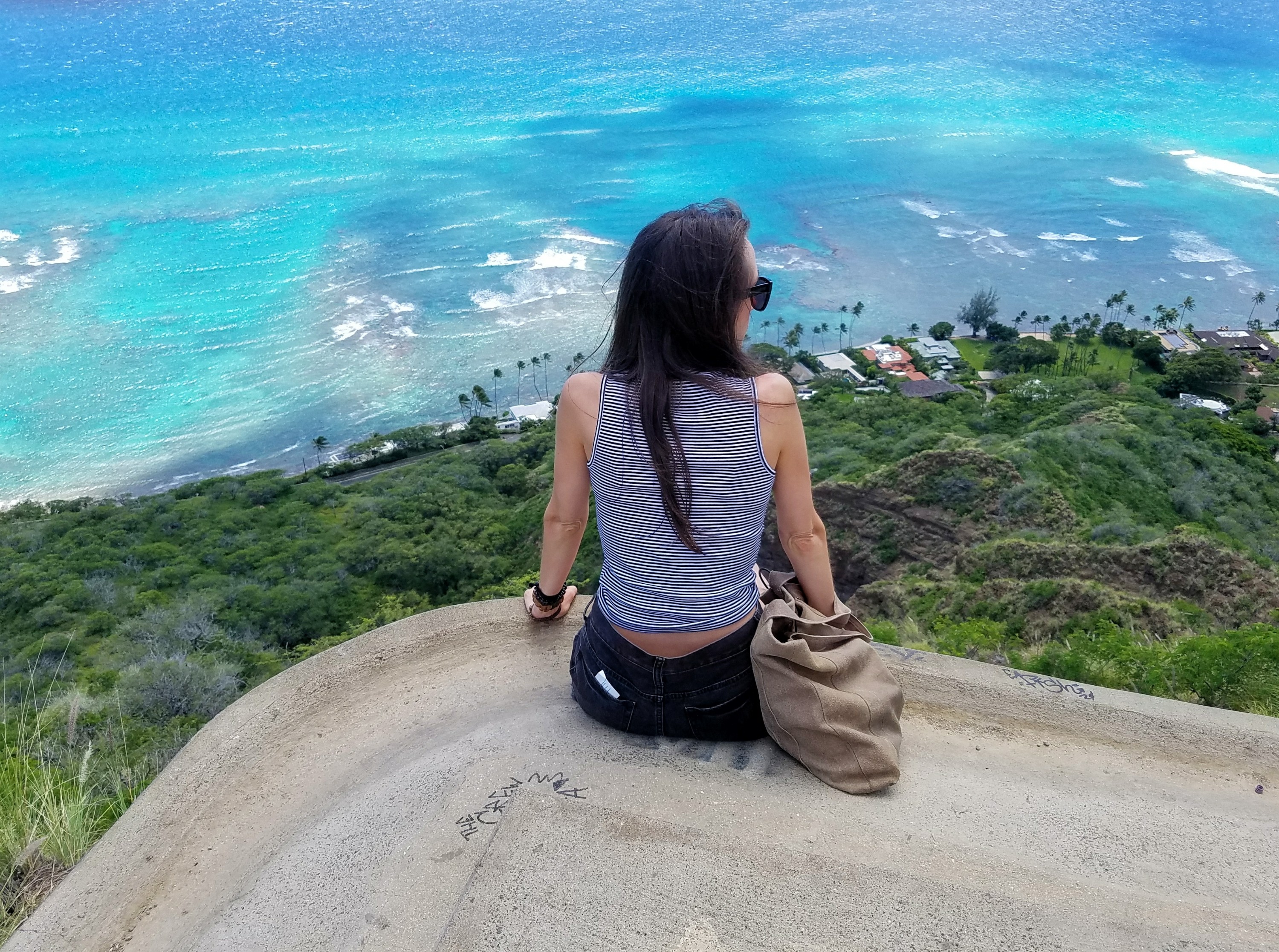 Woman sitting on edge looking at the ocean