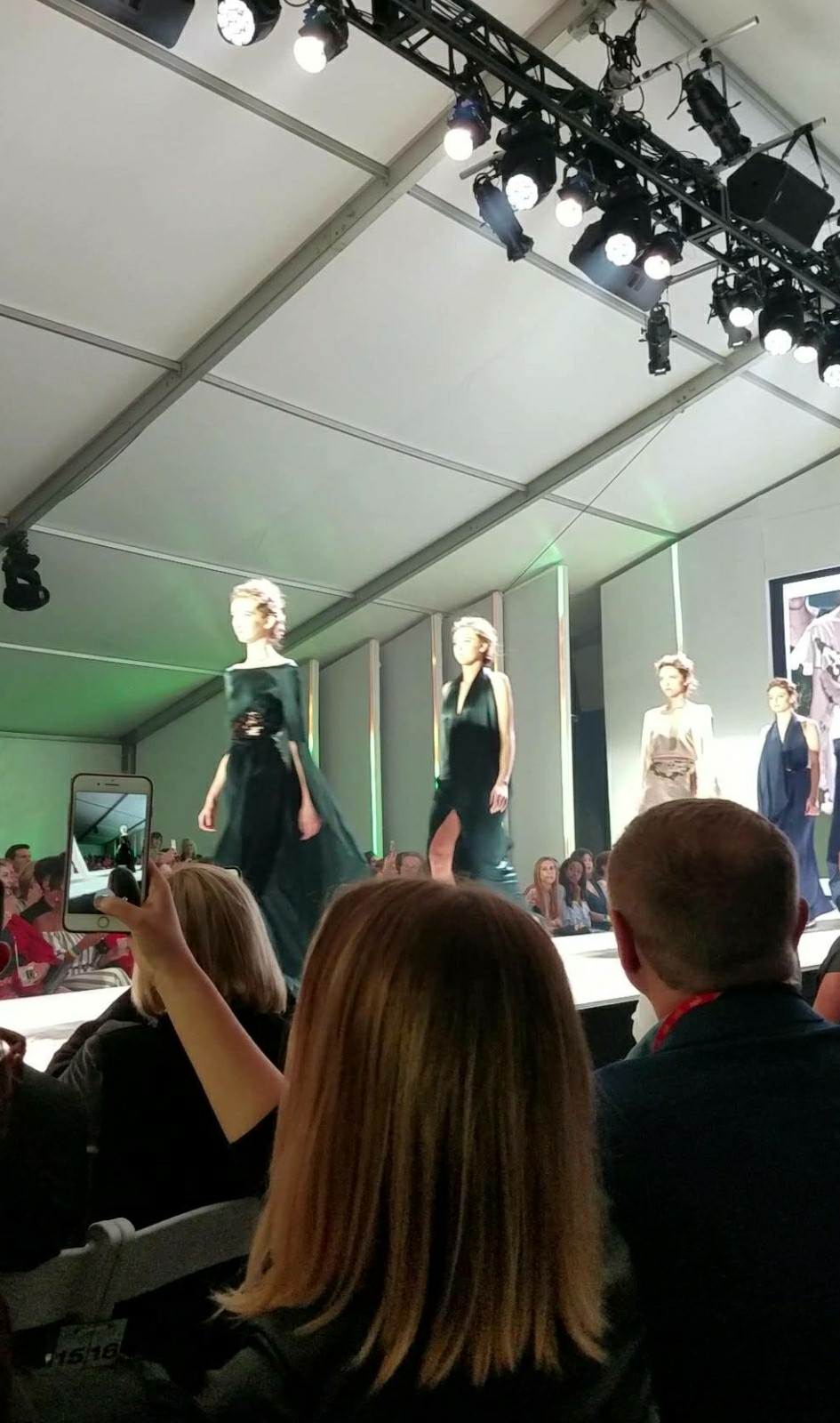 Models on a runway with people seated