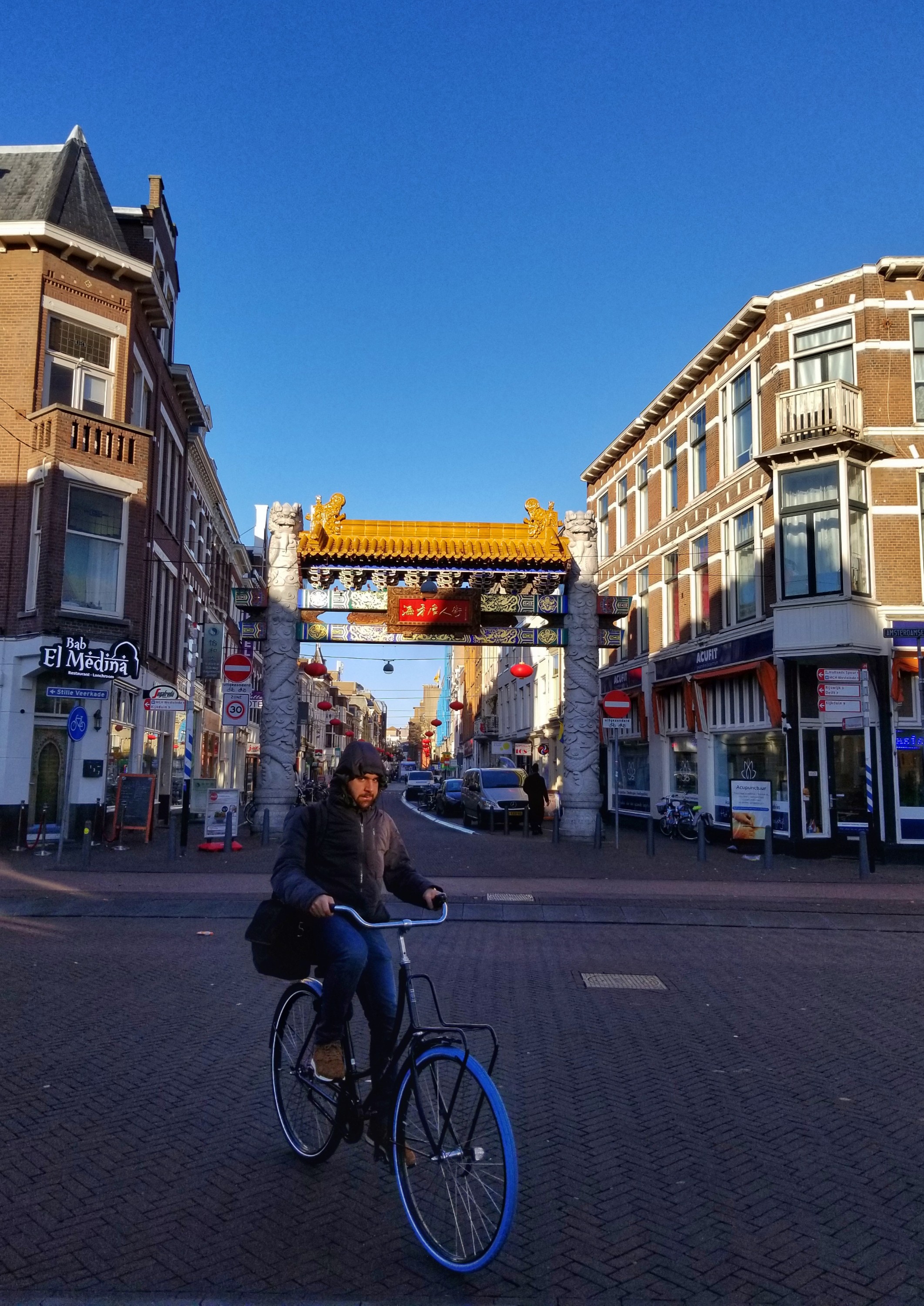 Man riding a bike in front of the China Town gate in The Hague The Netherlands
