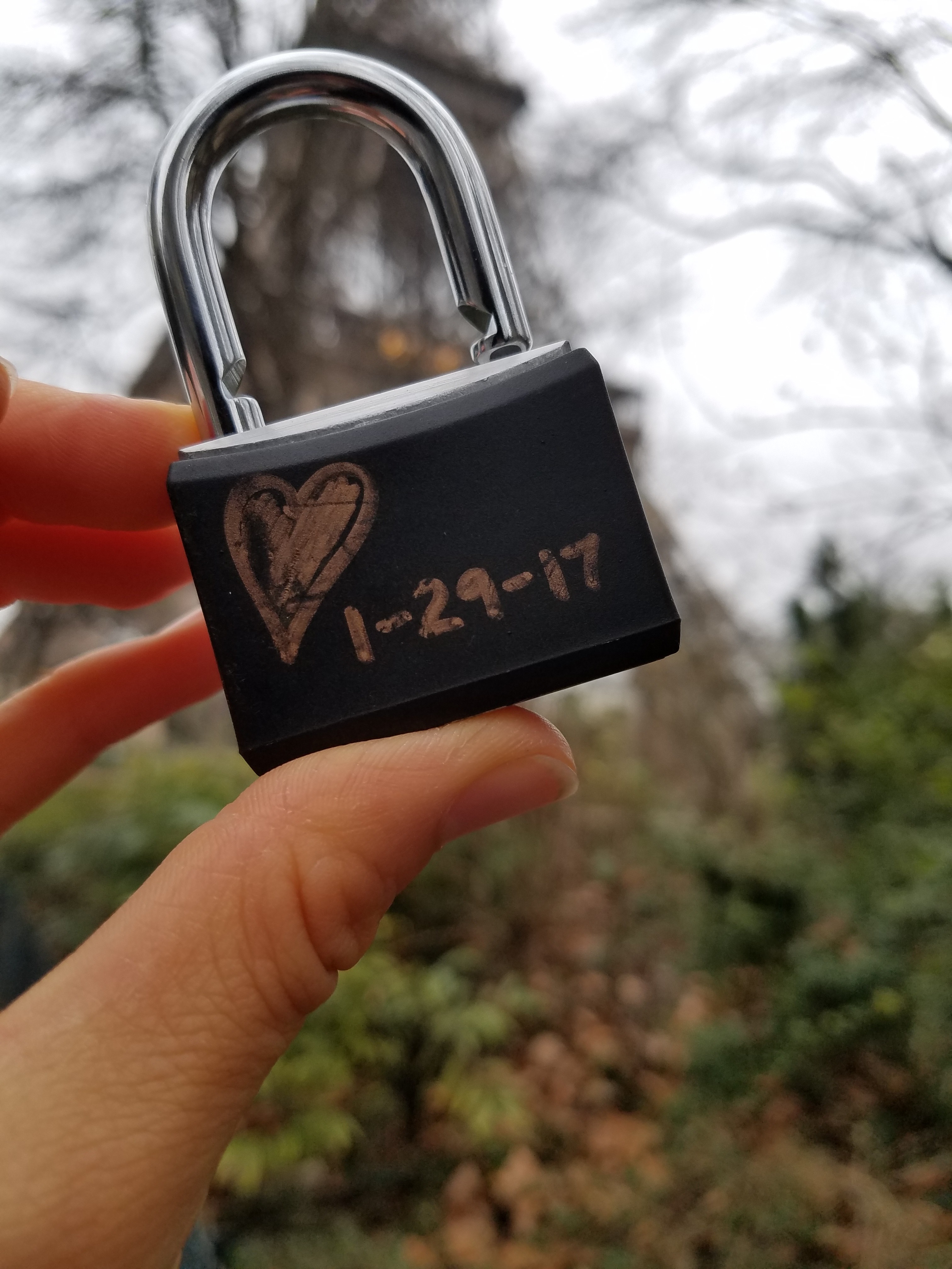 Hand holding up a lock with a heart drawn on it and date 1-29-17