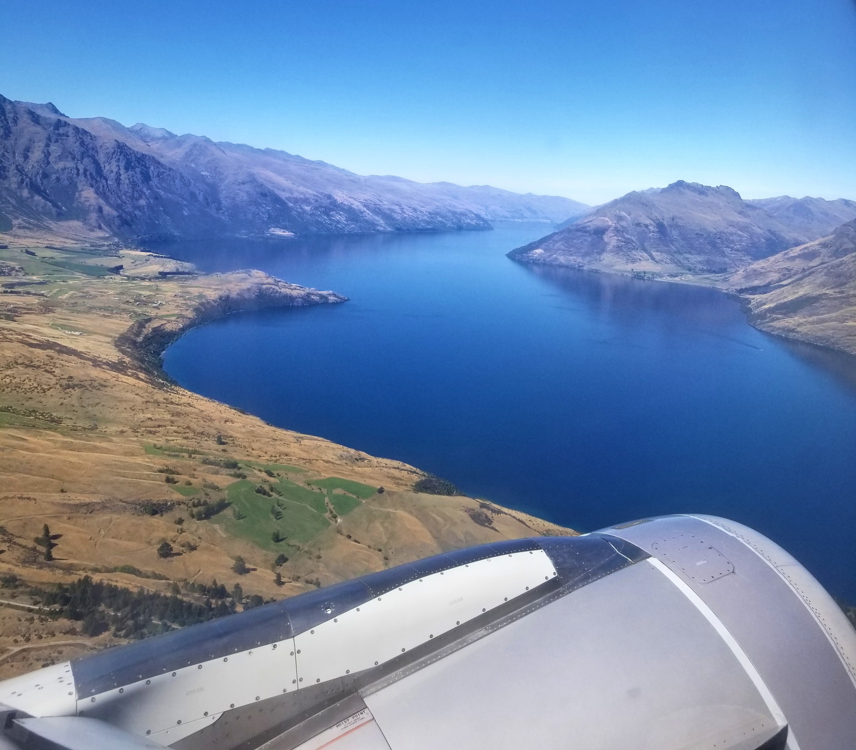 Blue water and mountains from a plane window