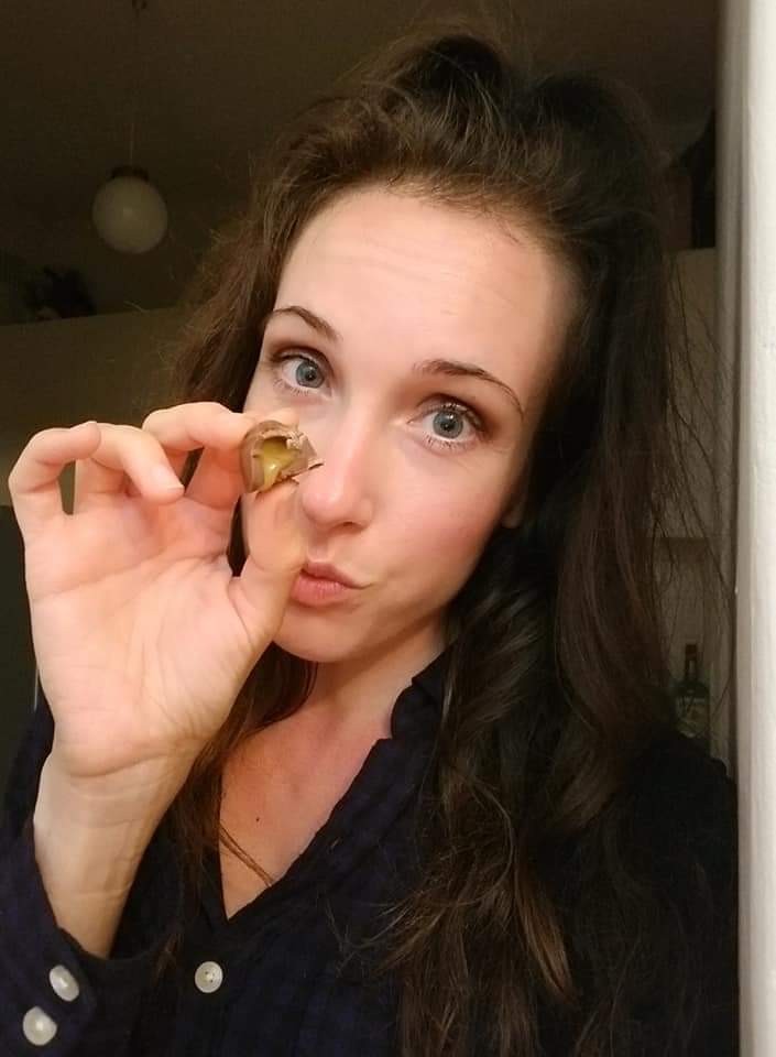 Woman holding a chocolate candy with honey filling