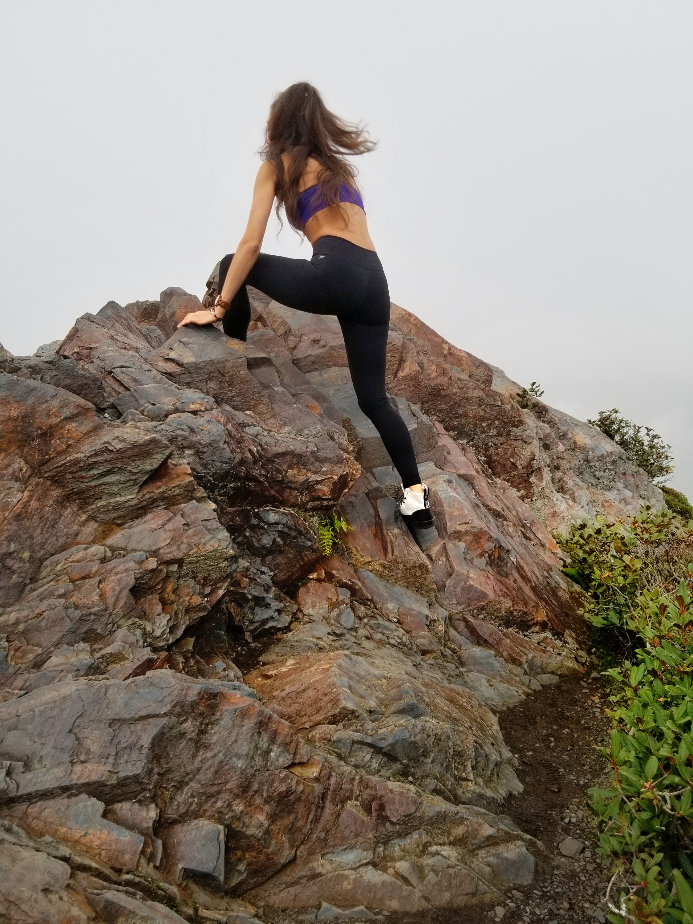 Woman climbing a large rocky surface