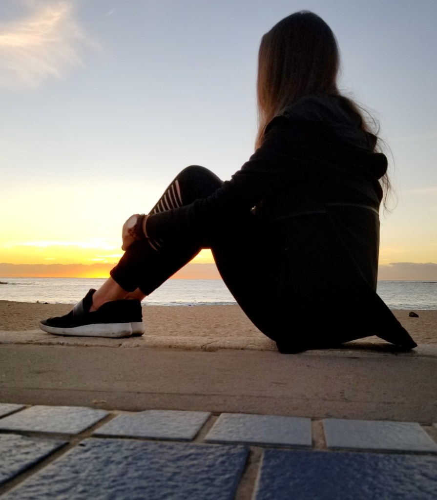 Woman watching sunrise on a beach