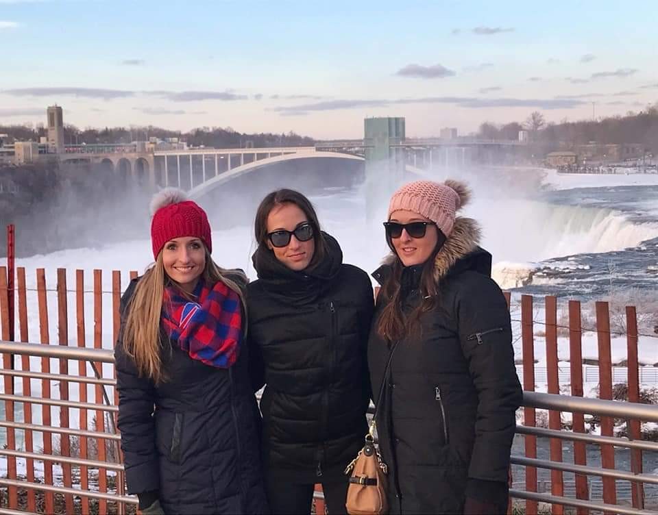 Three women posing in front of Niagara Falls