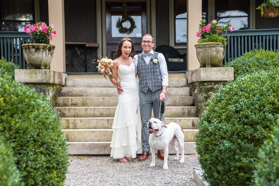 Husband and wife and dog in wedding attire