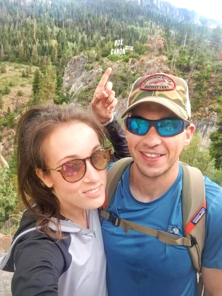 Woman and man hiking near Box Canon sign in Ouray, Colorado