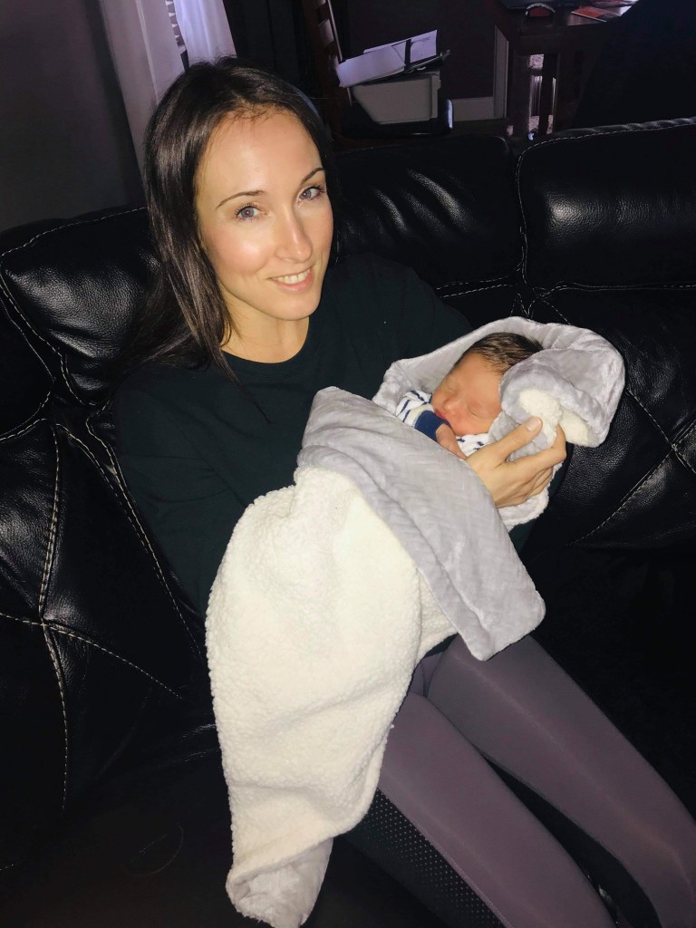 Woman holding a newborn baby on a couch