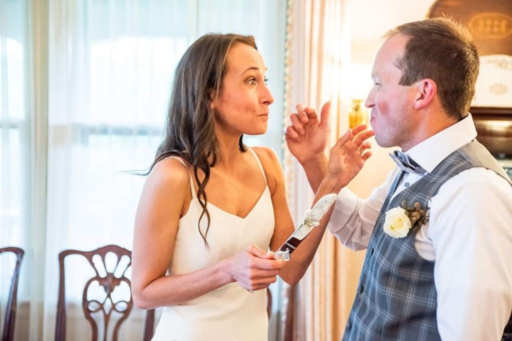 Bride and groom feeding each other wedding cake