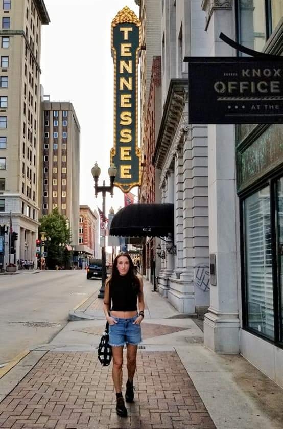 Woman walking down a brick sidewalk in a downtown area