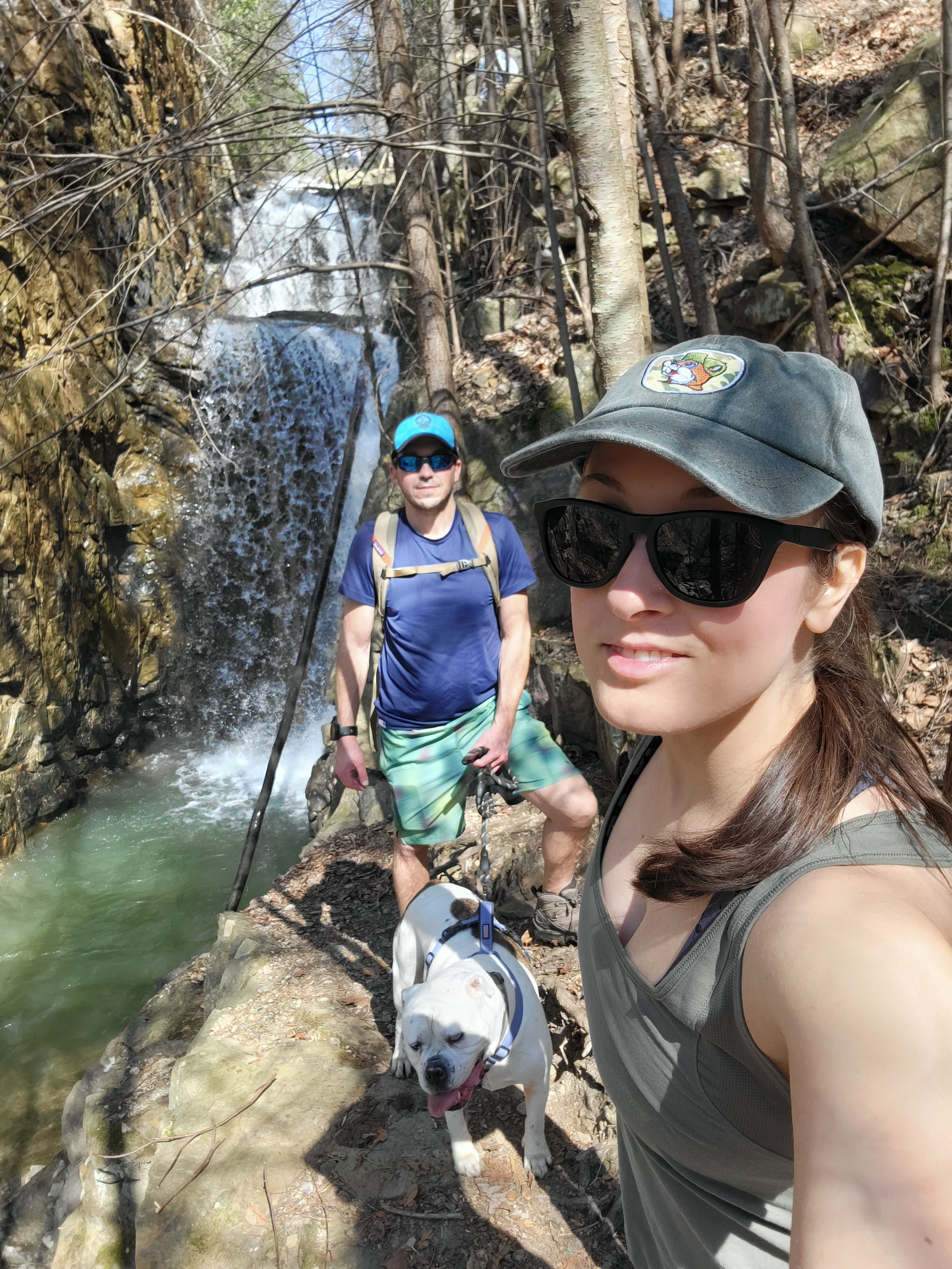 Woman, man, and dog in front of a waterfall in Tennessee
