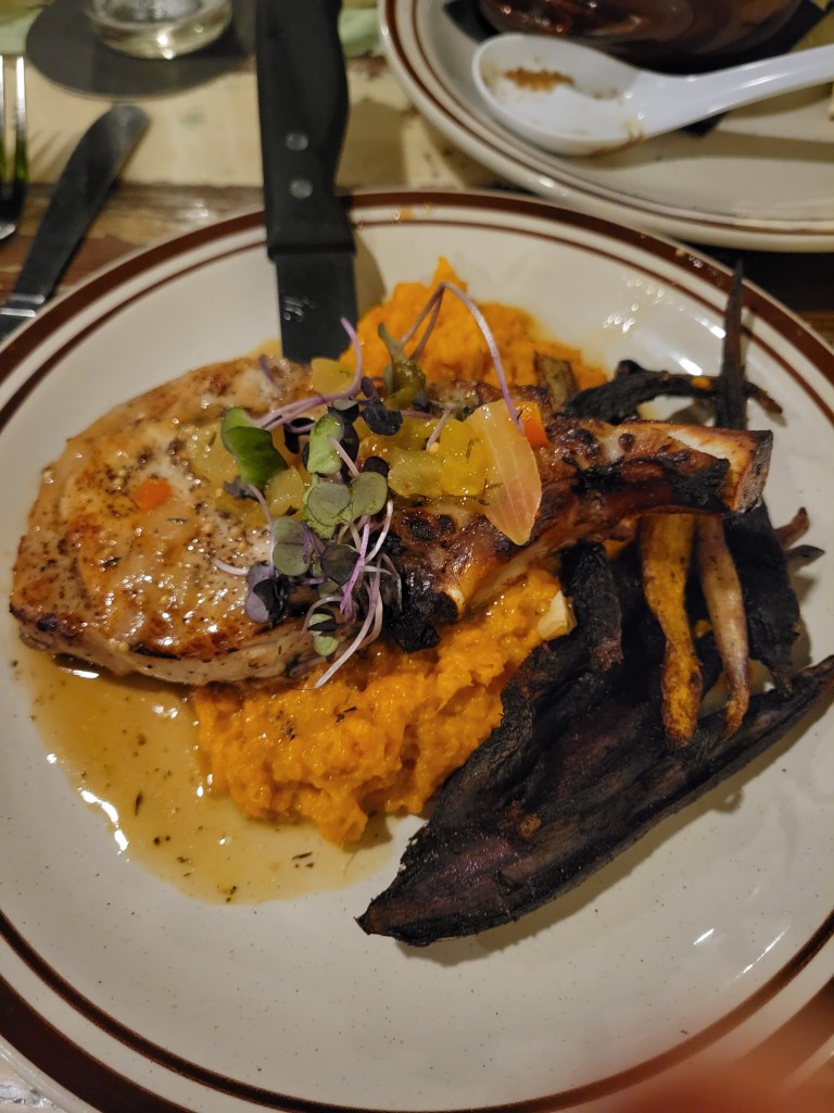 Plate of pork chops, mashed sweet potatoes, and roasted carrots
