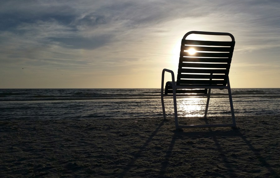 Silhouette of a beach chair on a beach at sunset