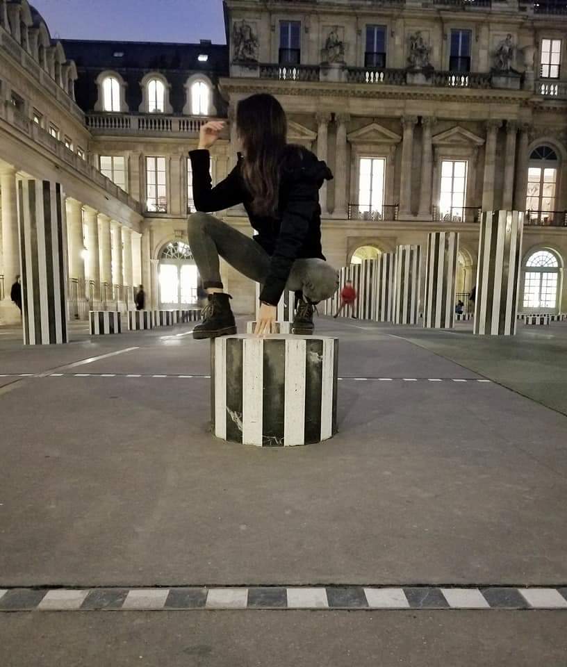 Girl crouching on a pillar AR Palais Royal in Paris France