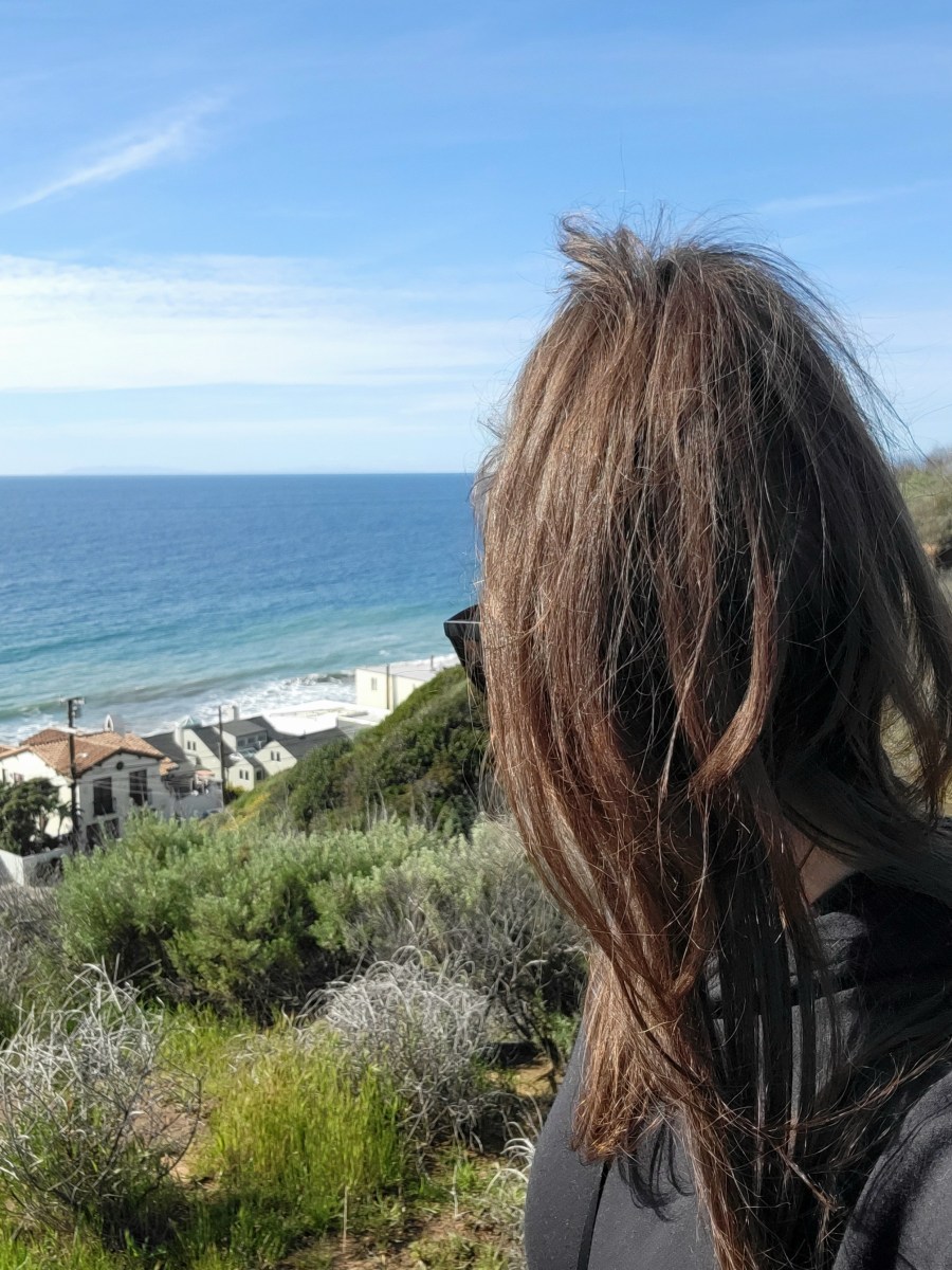 Woman with head turned toward the ocean