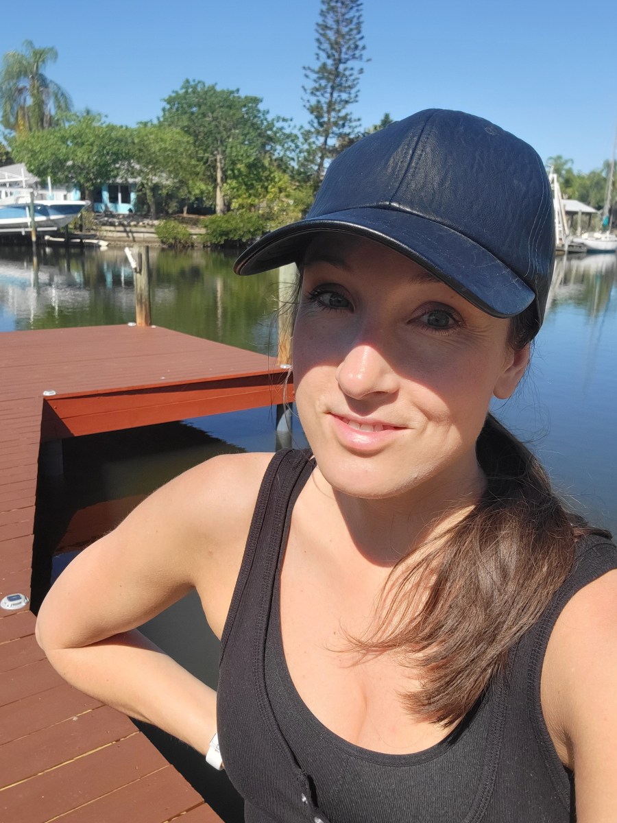 Woman wearing a black hat and standing next to a dock
