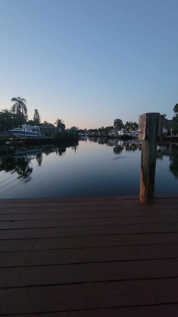 Canal at twilight with a ripple in the water near several docks