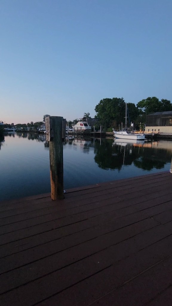 Canal at twilight with a ripple in the water near several docks 