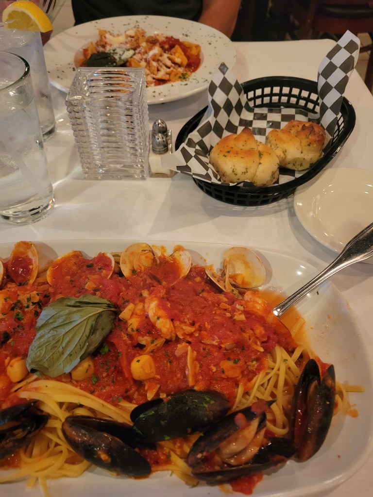 Seafood pasta with classic, garlic bread, and chicken parmesan at an Italian restaurant 