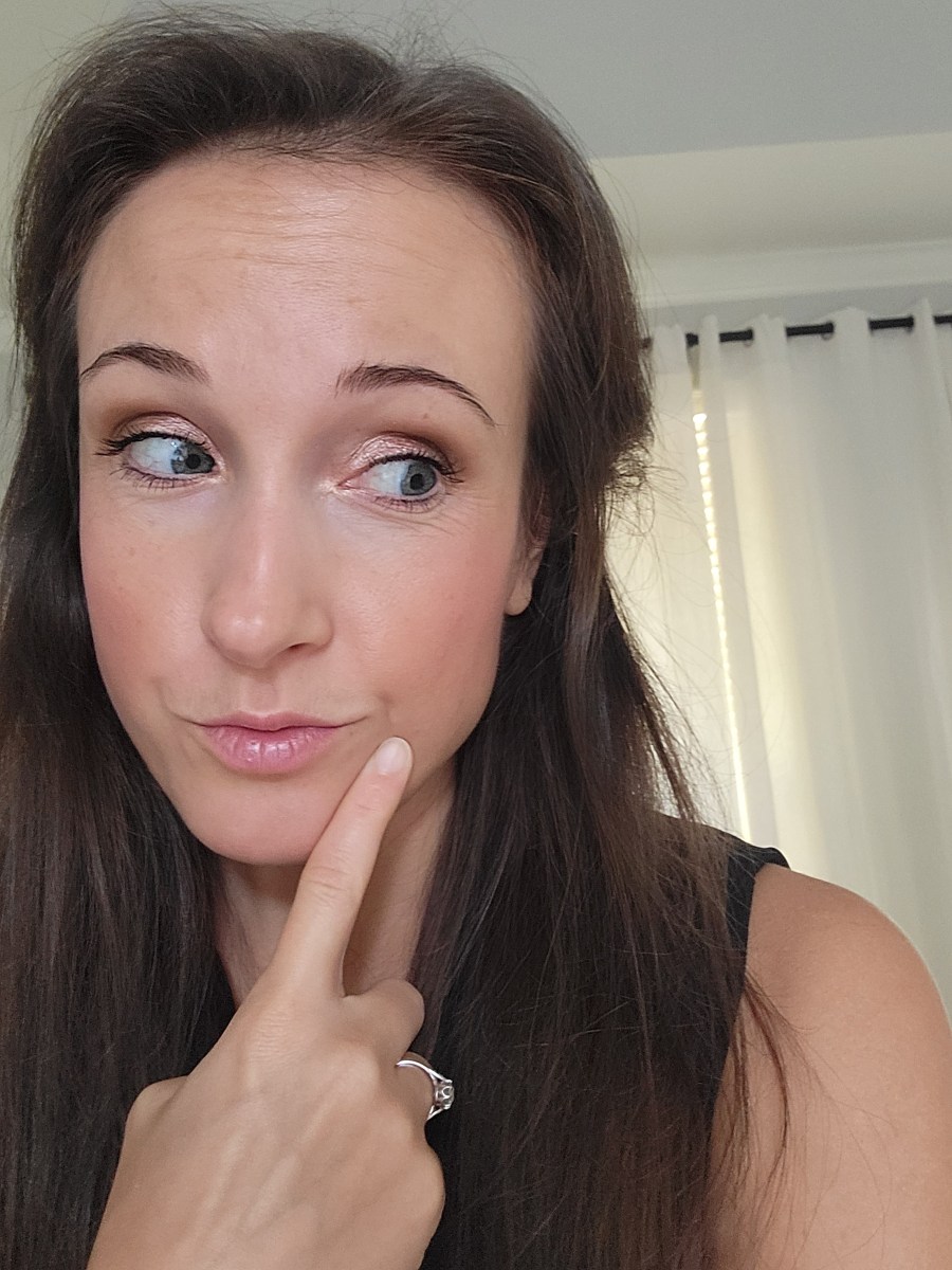 Woman with one finger pointing toward her face