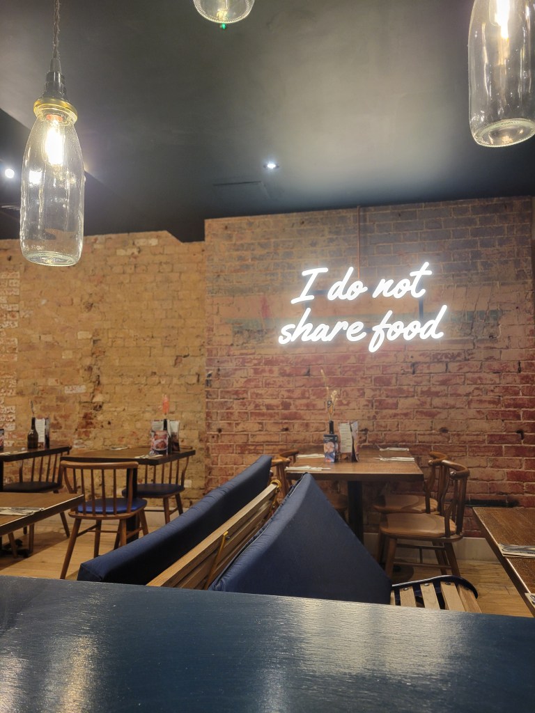 Interior of a restaurant with a sign that reads "I do not share food"