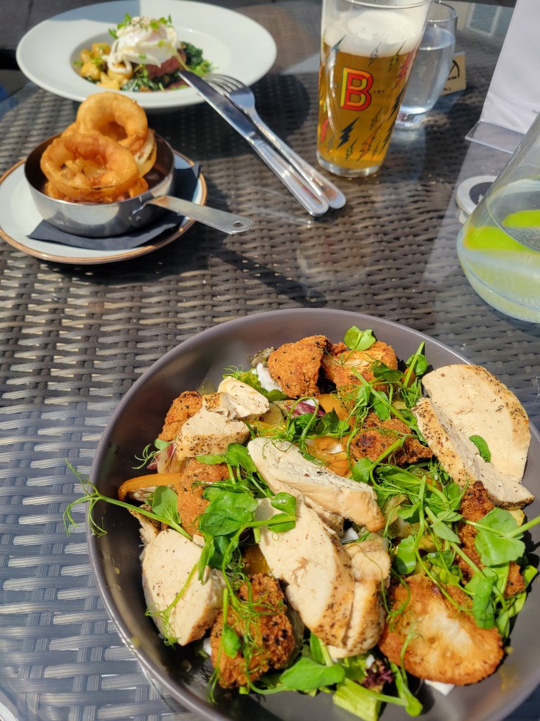 Plates of food and beer on an outdoor table