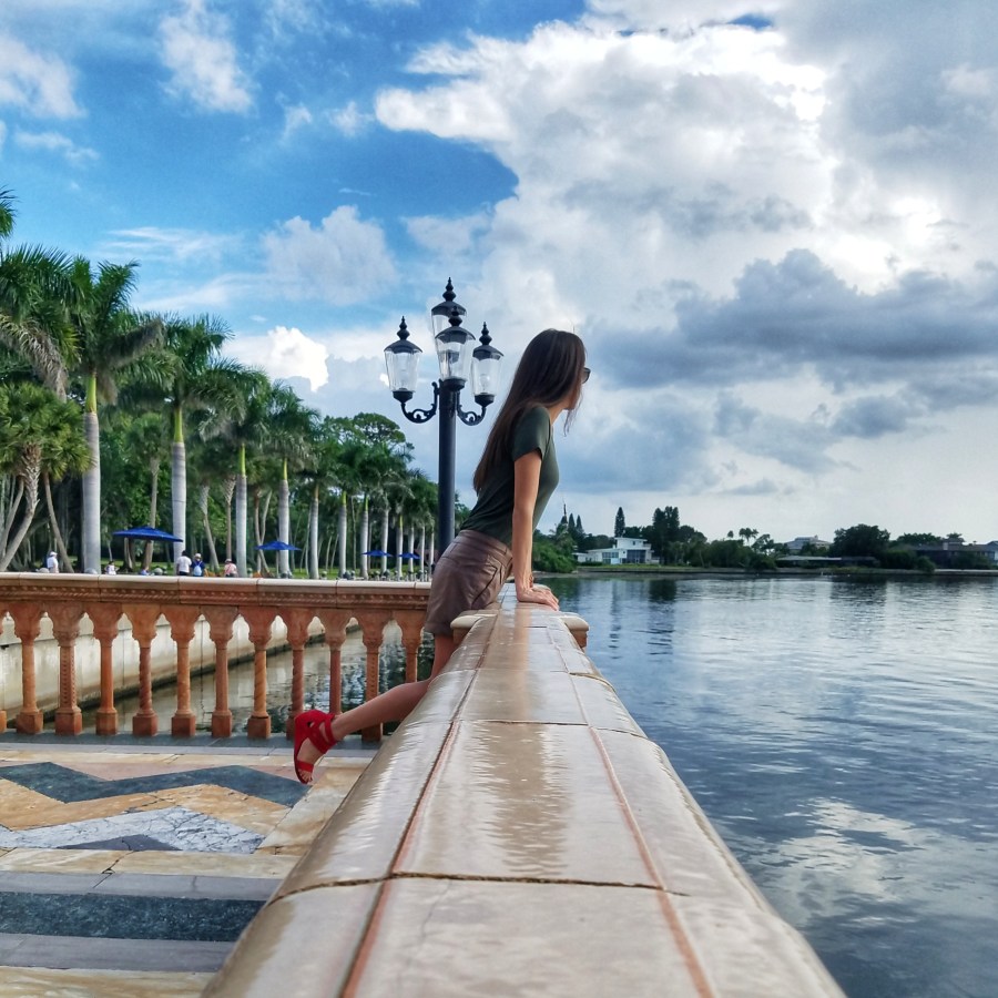 Woman leaning over a railing looking out at the water