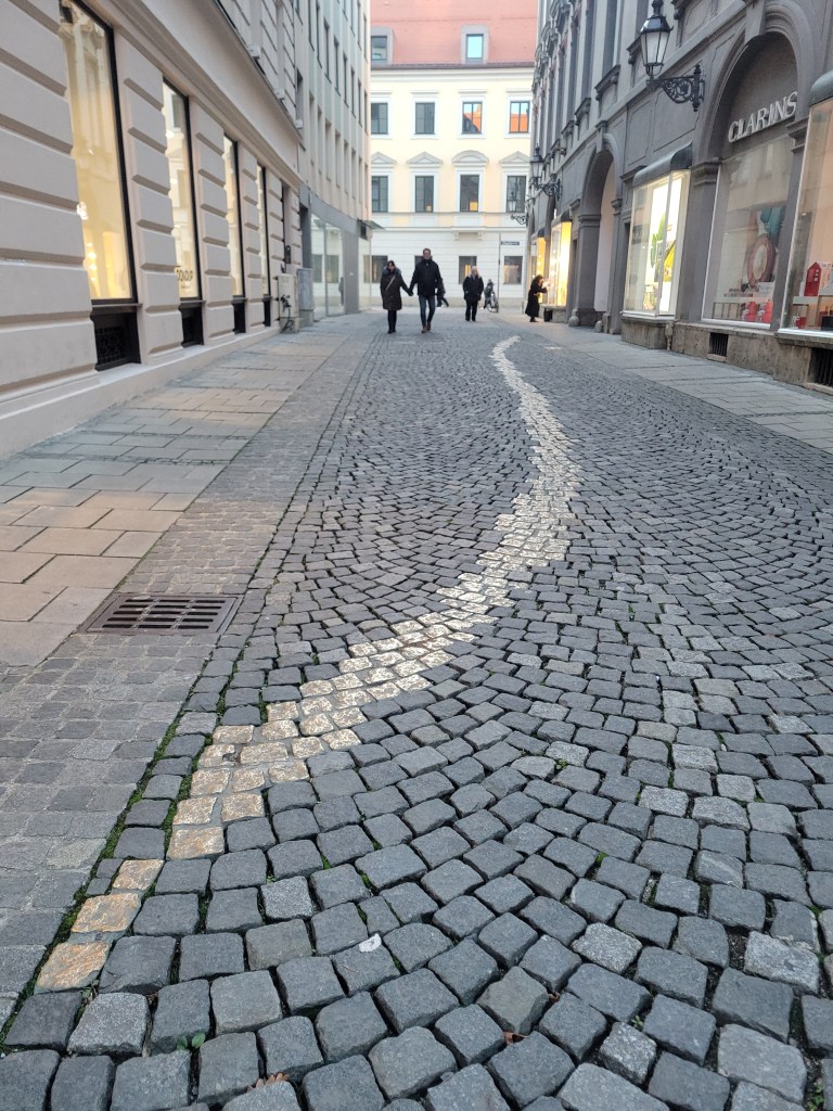 Viscardigasse cobblestone street with bronze paved path in Munich, Germany 