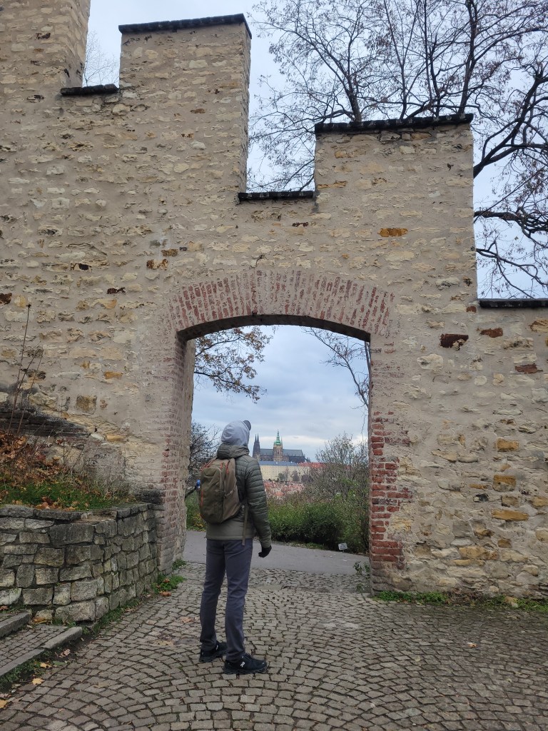 Man with a backpack looking at fortress walls in Prague 