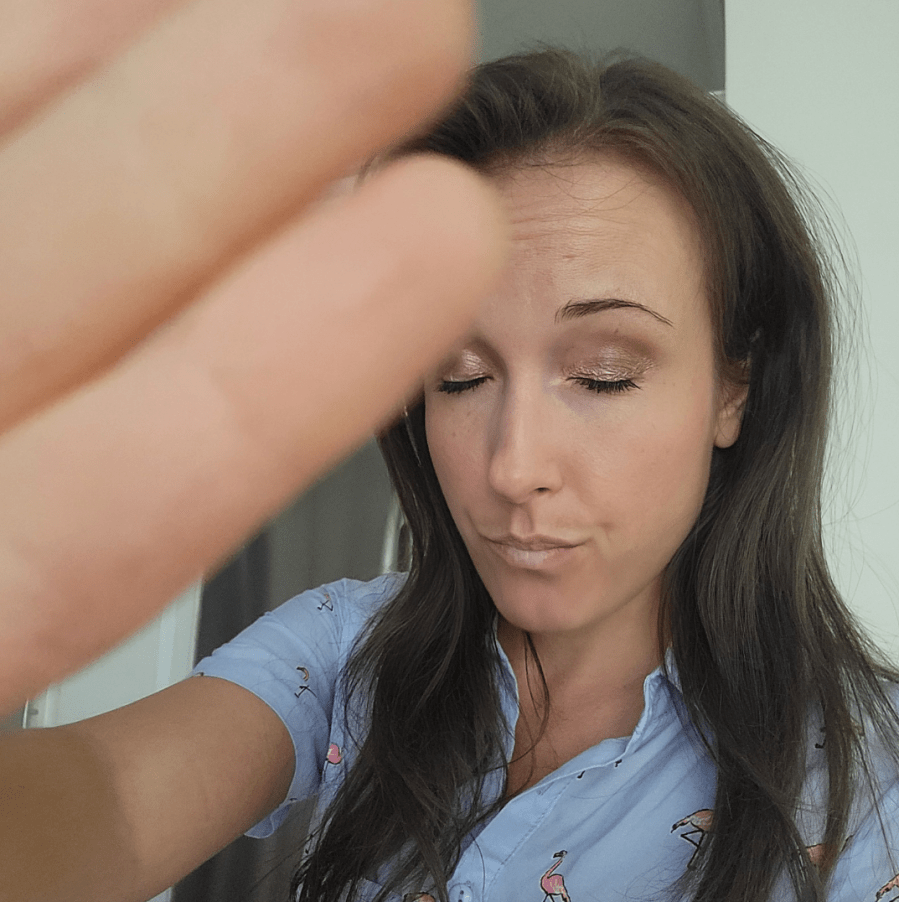 Woman closing eyes and holding hand up as if to say "stop"