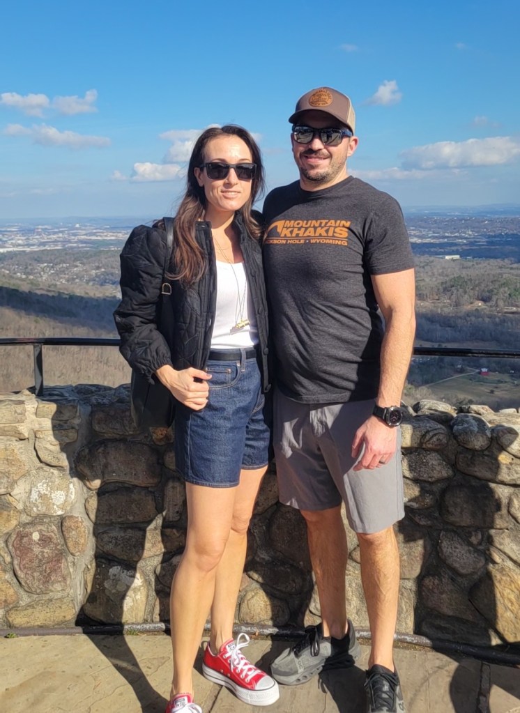 Woman and man posing on a mountaintop view point