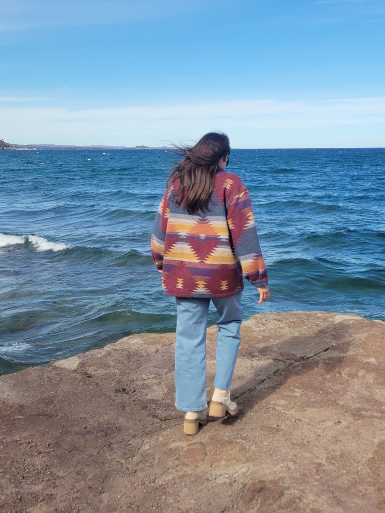 Woman walking on a rocky surface near Lake Superior 